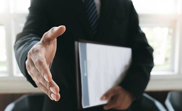 A businessman extends his hand for a handshake