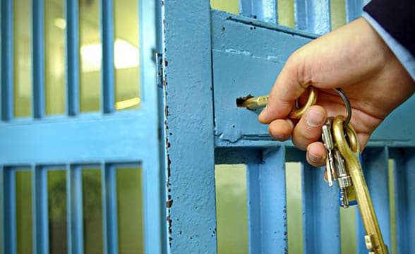 An officer locks a prison cell