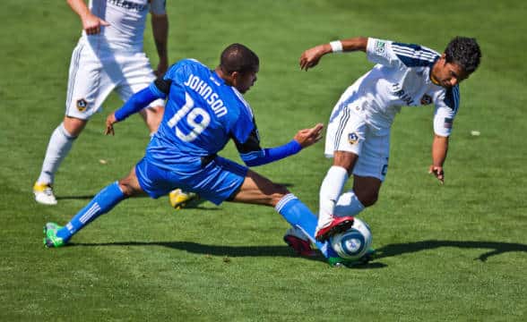 San Jose Earthquake player being contested for the ball.