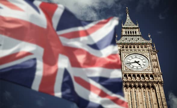 Flag of the United Kingdom next to the Big Ben clock tower