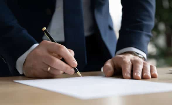 A person signing a contract.