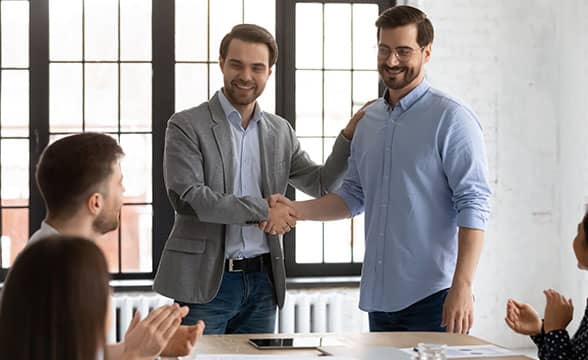 A senior employee welcomes a new hire to a company's team