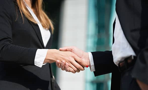 A businesswoman shakes hands with a colleague