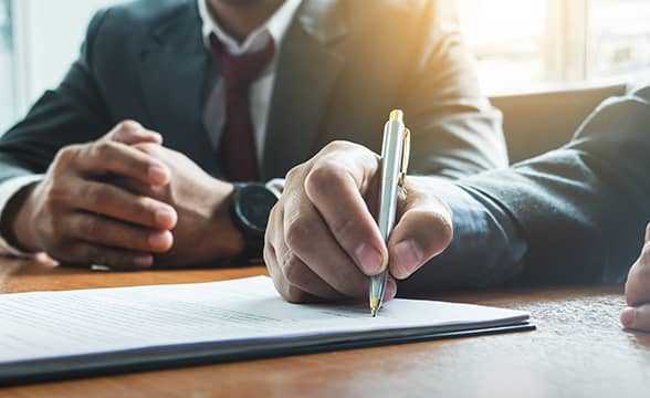 Two businessmen sign an agreement