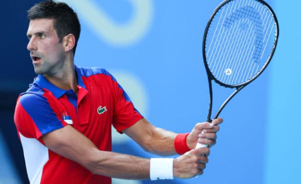 Djokovic taking a swing with his racket.