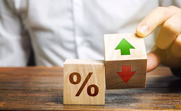 A person holds blocks representing a rising or declining percentage