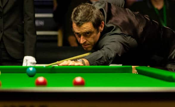 Ronnie O'Sullivan preparing to take a shot at snooker.