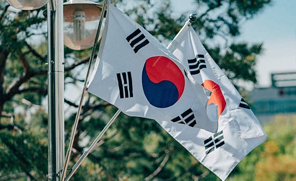 Two South Korean flags attached to a street lamp