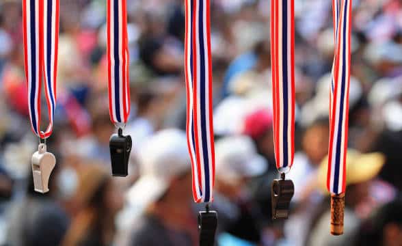 A bunch of sports whistles hanging from a cord.