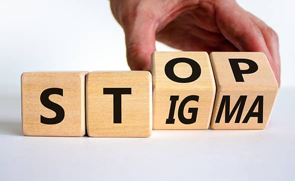 A person arranges cubes in a message, encouraging people to stop stigma