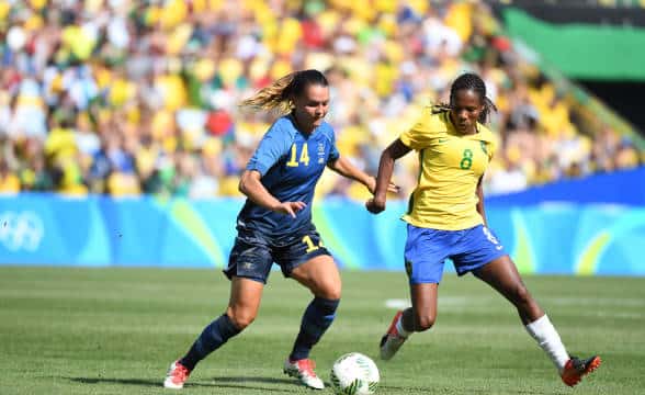 Two women vying for the ball in soccer.