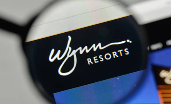 Wynn Resorts' logo under a magnifying glass