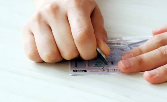 A person scratching away at a lottery ticket.