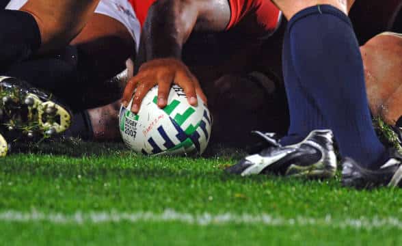 Rugby League players tackling.