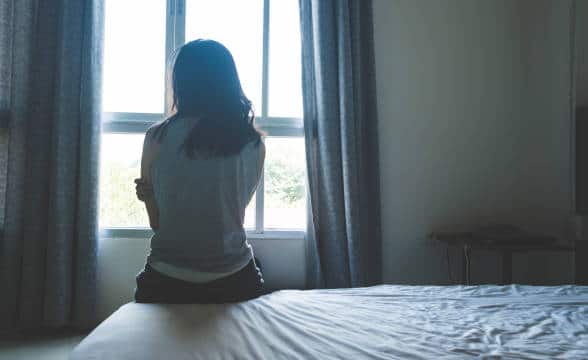 A human trafficking victim alone in a room.