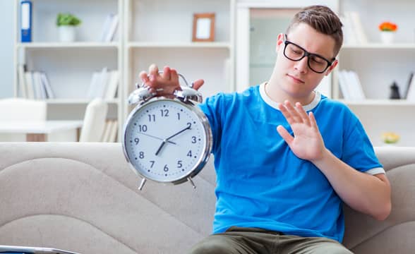 Man holding a clock indicating a pause