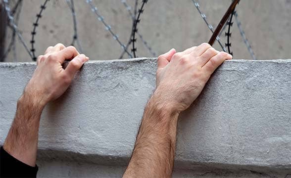 Prisoner climbs wall to escape jail.