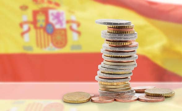 A pile of Euro cents with the Spanish flag in the backdrop