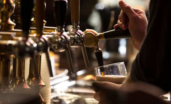 A man pouring a glass of beer.