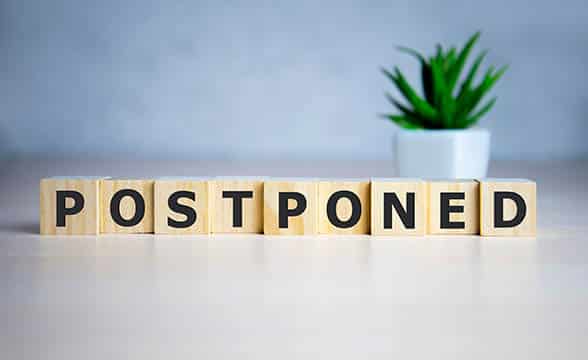 A row of cubes spelling "postponed"