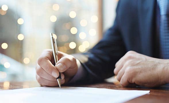 A businessman signs a document