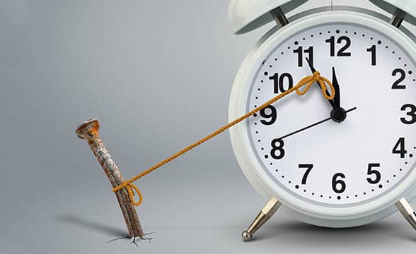 A nail with a string stops a clock's arrows from moving. Delay concept