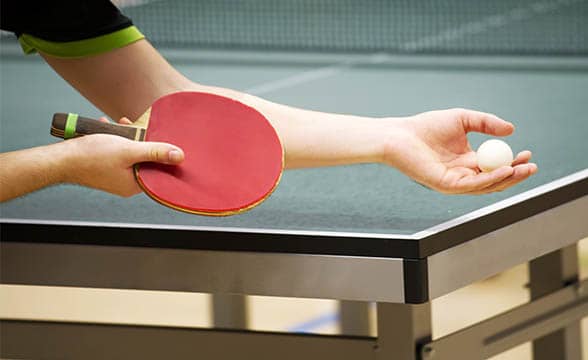 A table tennis player prepares to serve