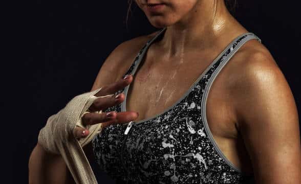 UFC Fighter putting bands on her hand.