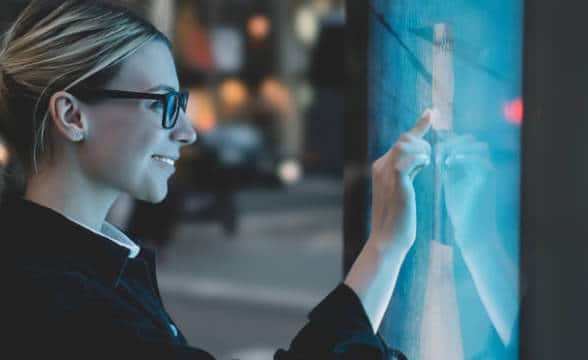 A woman touching a screen.