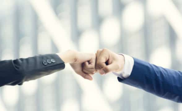 A businessman and businesswoman making a fist bump