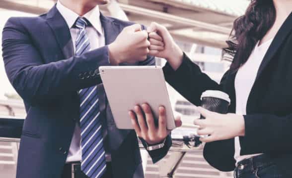 Business partners male and female giving fist bump