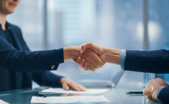 Businessman and businesswoman shaking hands after a deal