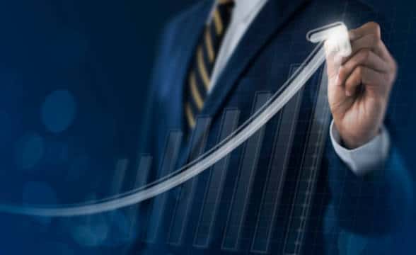 Businessman pointing to a financial graph that shows growth