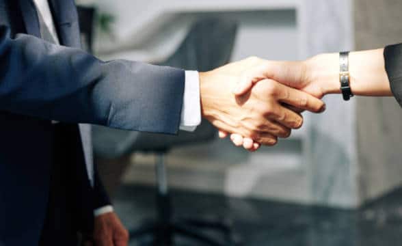 Close up photo of a businessman shaking hand with a businesswoman