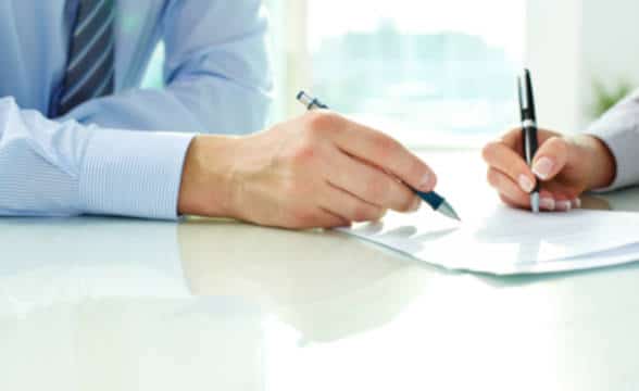 Close up photo of the hands of businessman and businesswoman signing documents