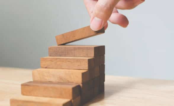 Hand arranging blocks as steps