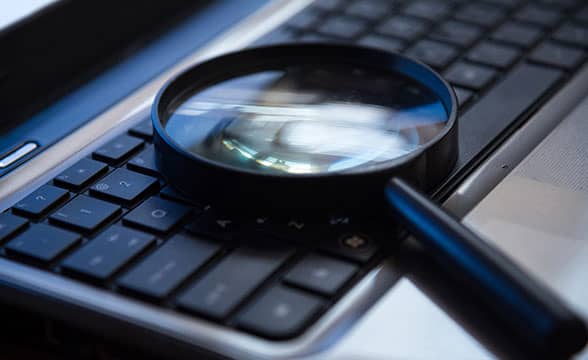 A magnifying glass on a keyboard