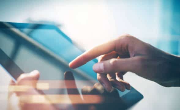 Close up photo of a man's hand on a tablet