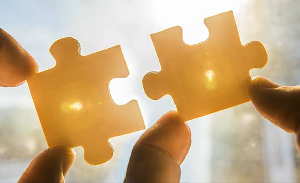 Person joins two puzzle pieces together