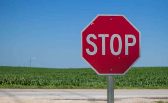 Stop sign on a poll in the middle of a field