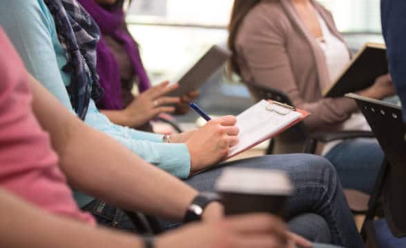 A group of students taking notes during lecture