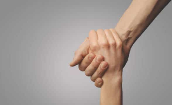 Two hands holding together, a rescue gesture