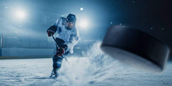 An ice hockey player shooting a puck.