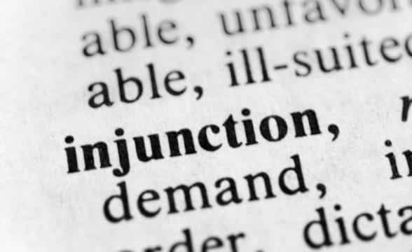 The word injunction written on a piece of paper.