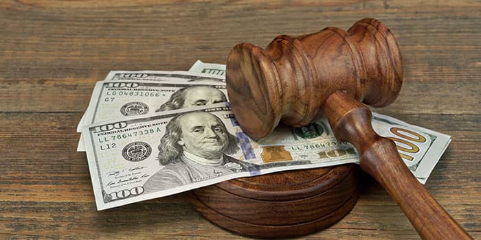 A judge's mallet sits on a few dollar bills