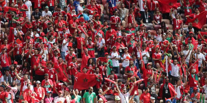 Morocco fans in a stadium cheering for their soccer team.