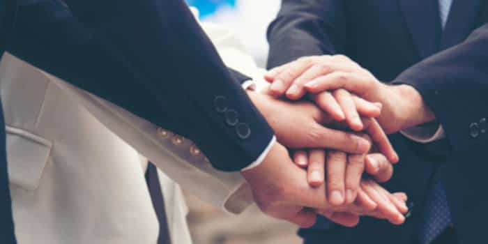 Businessmen and businesswomen joining hands