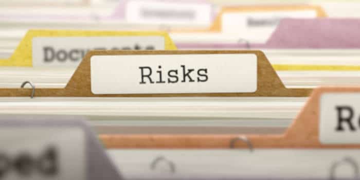 A close up focus on a file that says Risks in a file cabinet