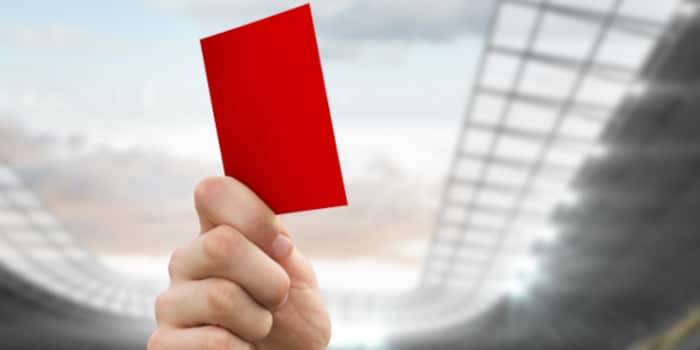 Close up photo of a hand holding a red card - soccer