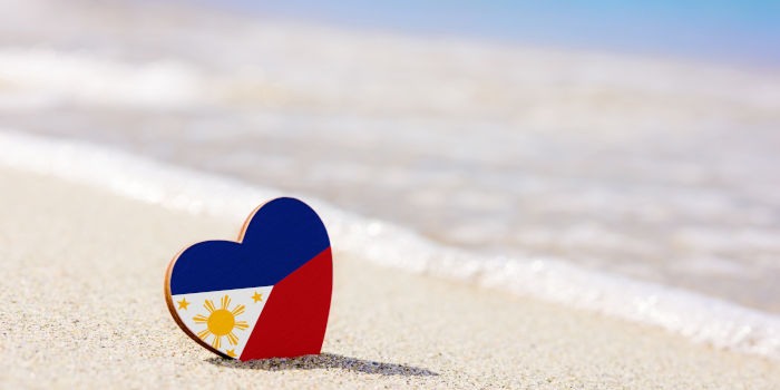 An item shaped like a human heart on a beach in the colors of the Philippines' national flag.